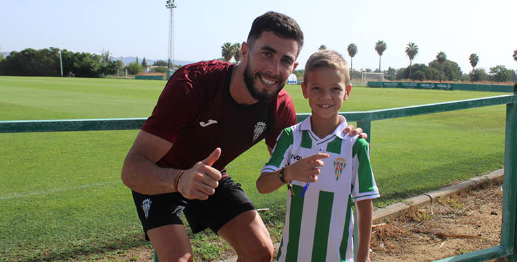El hábil extremo Jacobo González mira a la cámara de Cordobadeporte junto a un joven cordobesista tras firmarle un autógrafo.