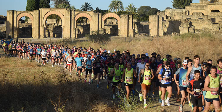 Los atletas corriendo los primeros metros tras el pistoletazo de salida con Medina Azahara al fondo.