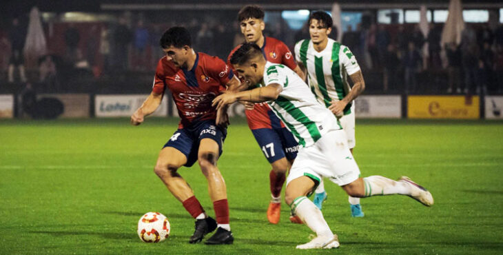 Jude Soonsup-Bell, al fondo, observa el lance entre Kuki Zalazar y un jugador del cuadro olotense. Foto: @UEOlot1921