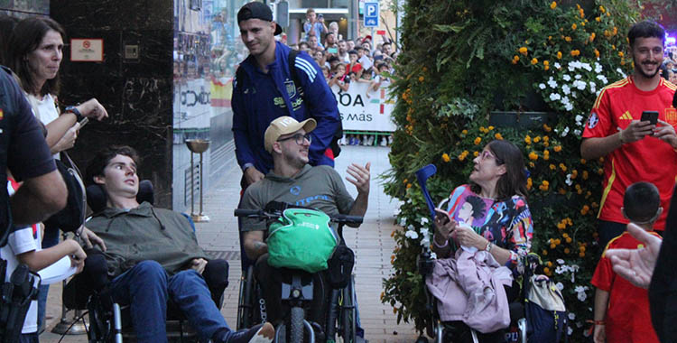 Álvaro Morata posando con un grupo de discapacitados a su llegada al Hotel Center.