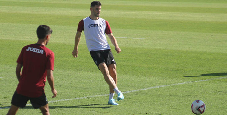 Carlos Albarrán pasando el balón ante la llegada de Calderón.