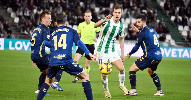 Ander Yoldi intenta marcharse entre dos jugadores del Tenerife.