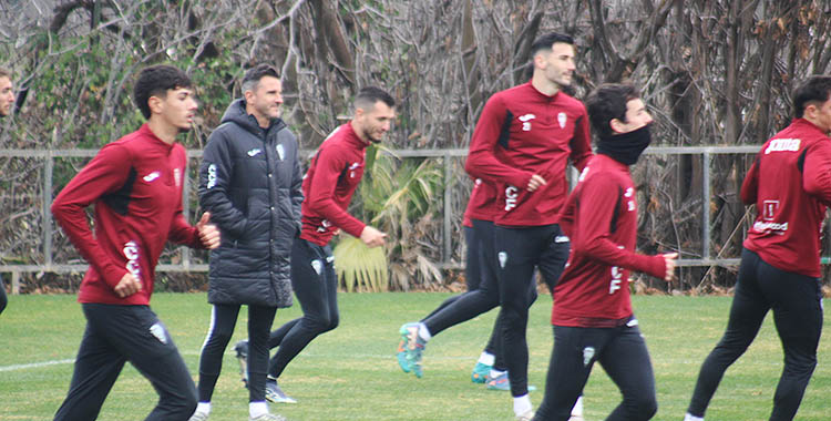 Iván Ania sonriendo entre sus jugadores, con Adri Lapeña a sus espaldas.