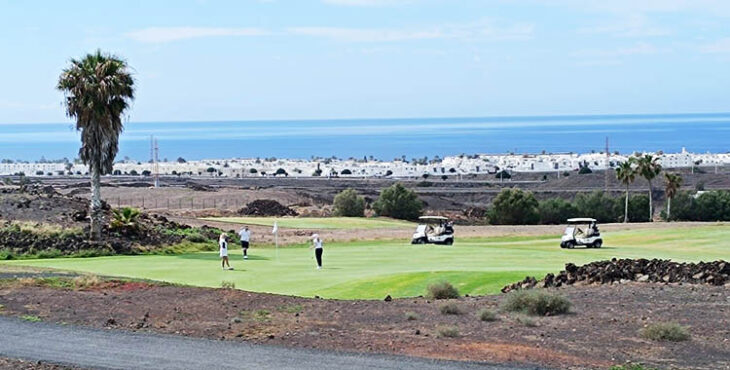 Vista panorámica del trazado de Lanzrote golf ente la arena volcánica y el océano atlántico al fondo que le confieren el carácter links.