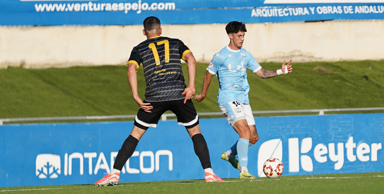 Sergio Rivera busca un pase ante un jugador del Tomares.