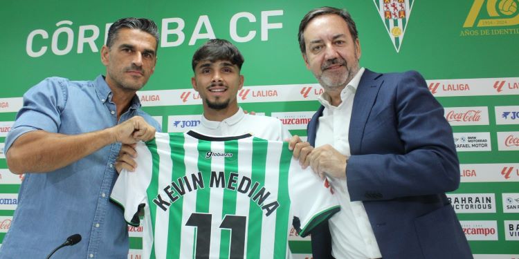 Kevin Medina mostrando la blanquiverde entre Juanito y Monterrubio.