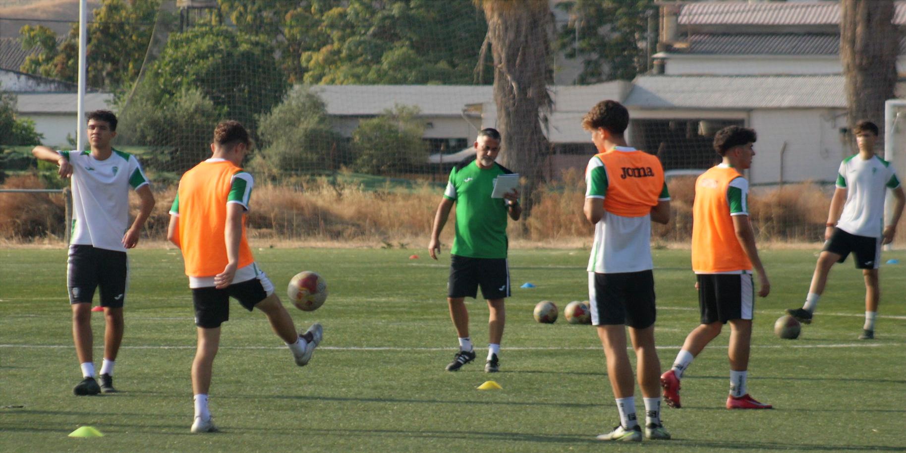 Los juveniles del División de Honor del Córdoba CF con su entrenador, Pedro López, al fondo.