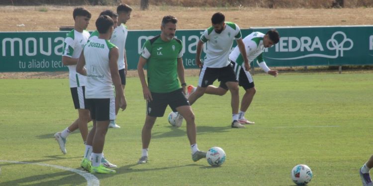 Iván Ania mirando el balón ante sus hombres.