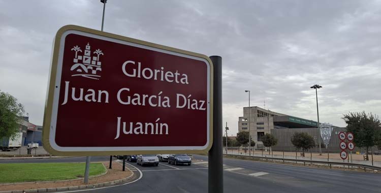 Placa dedicada a Juanín con El Arcángel al fondo.