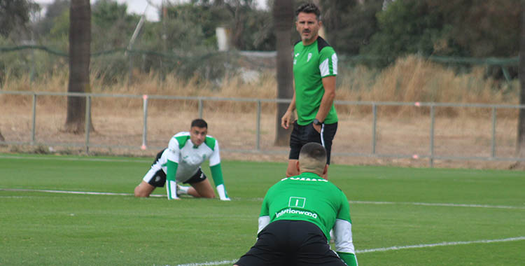 Iván Ania mirando a sus jugadores mientras estiran en la Ciudad Deportiva.