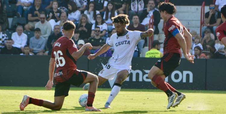 Konrad de la Fuente intenta salvar la presión de dos rivales.