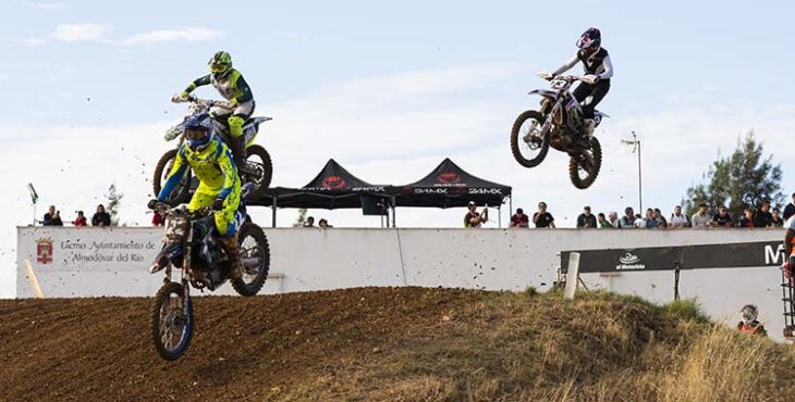 Tres pilotos volando con sus motos en el motocross de El Pinillo de Almodóvar del Río.