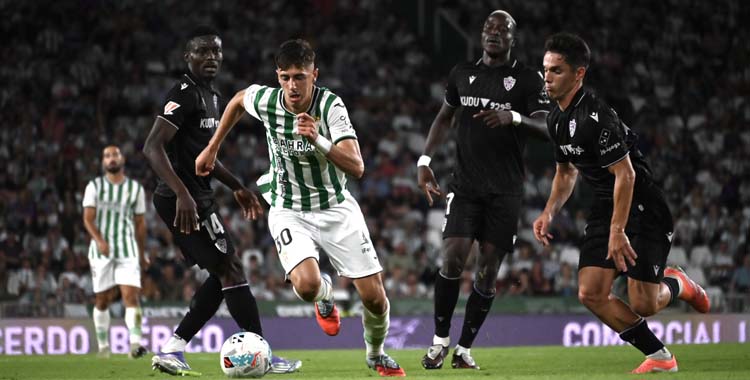 Requena conduce el balón ante la presión de tres rivales.