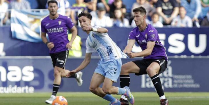 Pedro Ortiz trata de frenar a un jugador del Málaga.