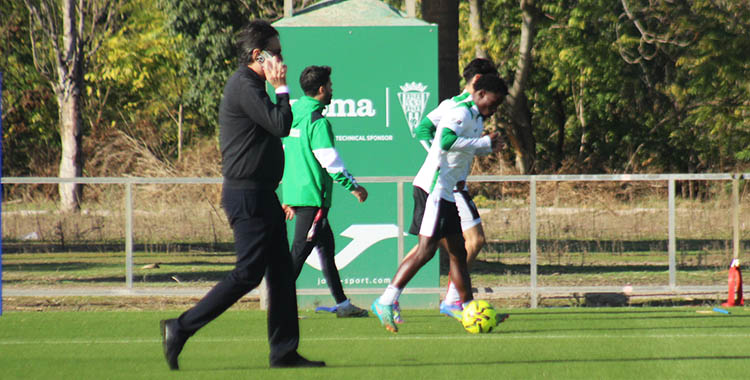 Antonio Fernández Monterrubio atravesando el terreno de juego al teléfono con Adilson y Álvaro Gómez al fondo.