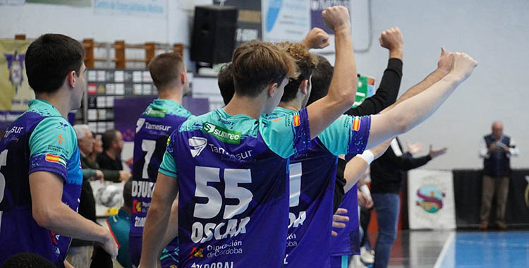 Óscar McCormick alza el brazo en señal de victoria en el banquillo con varios compañeros.