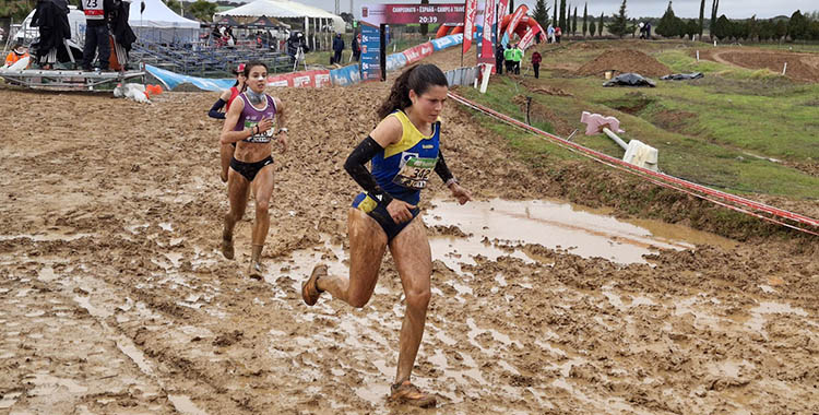 Las atletas sorteando los charcos entre el fango del circuito de El Pinillo en el Nacional de Cross en Almodóvar del Río.