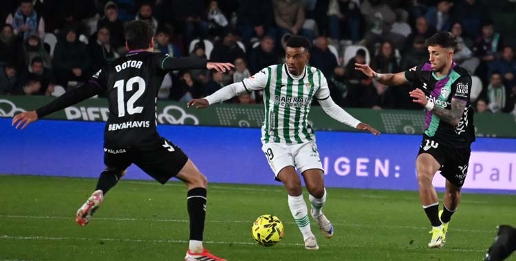 Dalisson conduce el balón ante dos jugadores del Málaga.