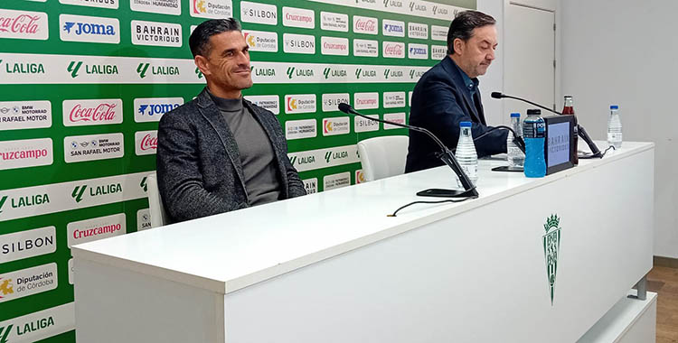 Juanito esbozando una sonrisa frente a la seriedad de Monterrubio en su comparecencia ante los medios.