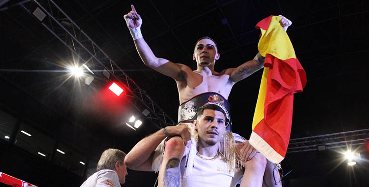 Rafa Lozano a hombros con su cinturón de campeón y la bandera de España.