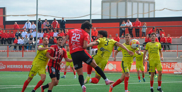 Ismael García rematando un balón ante la Deportiva Minera. Foto: Tino Navas / Salerm Puente Genil